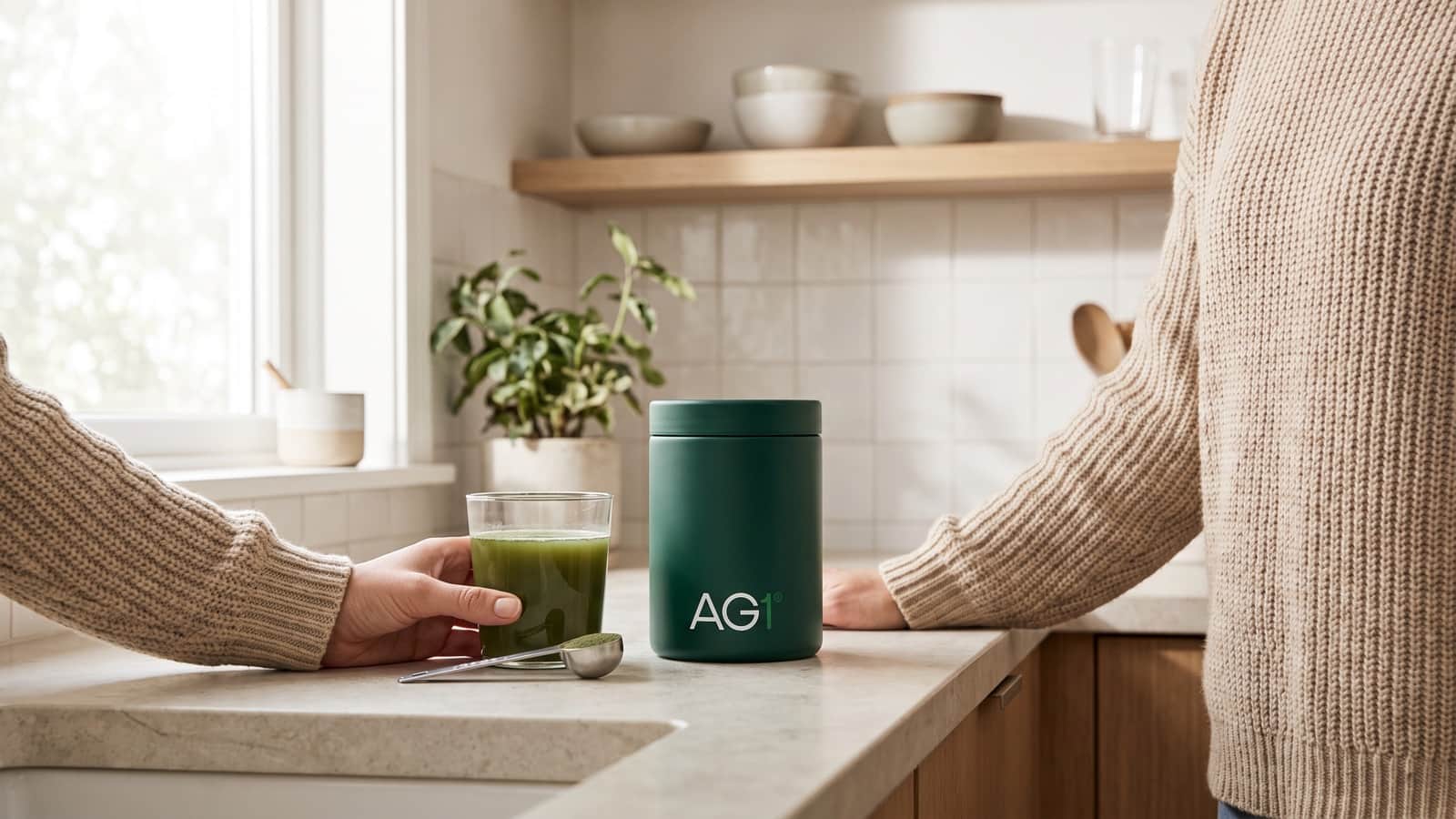 La boisson nutritive verte AG1 et la boîte AG1 posées sur un plan de travail de cuisine clair, dans la lumière du matin